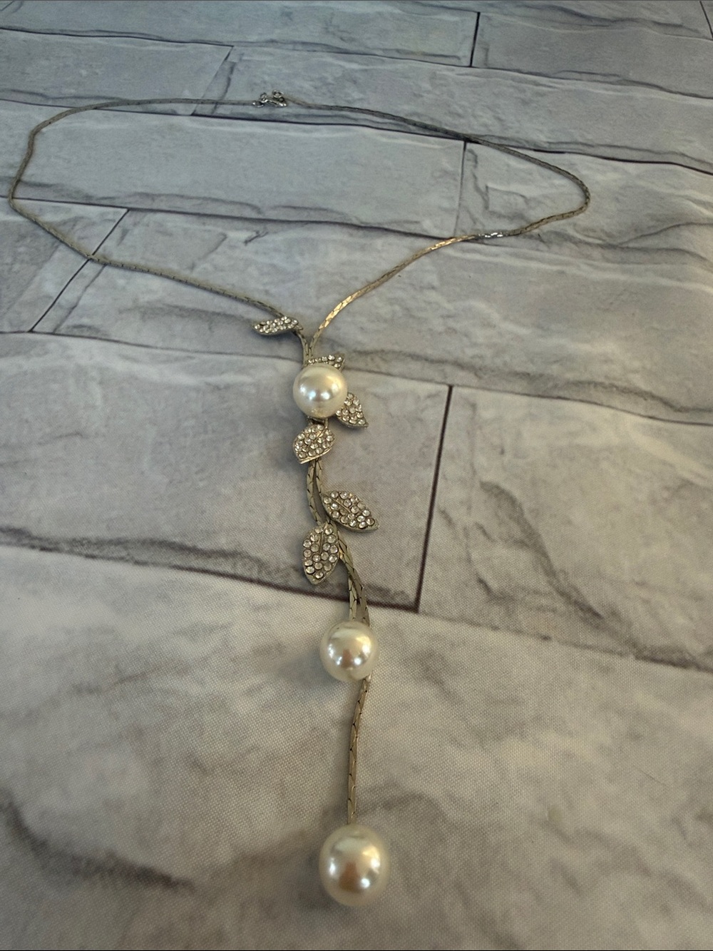 VTG lariat-style necklace adorned with faux pearls and rhinestone leaf pendants